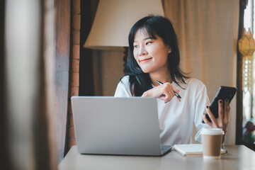 Business freelance concept, Pensive young Asian woman gazing away while working on a laptop and...
