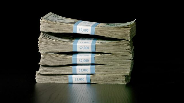 Stack of money falling and landing on a table. Slow Motion.
