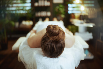 relaxed 40 years old woman in spa salon laying on massage table