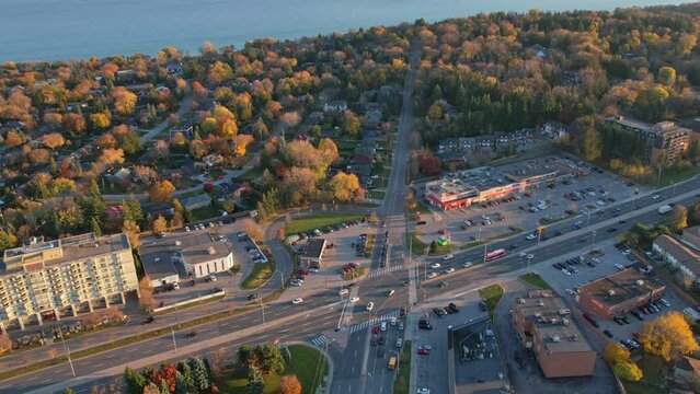 Aerial time lapse view of main intersection or road junction with moving cars in American town.  Busy road in residential area. Traffic and congestion viewpoint from above. Sun set and golden hour.