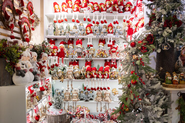 Naklejka na ściany i meble Christmas souvenirs on shelves for sale in the shop, featuring various Christmas toys showcased in the festive store. Embracing the winter holidays concept.