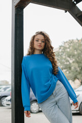 Fashion portrait of a stylish young girl on the urban background of a city street.