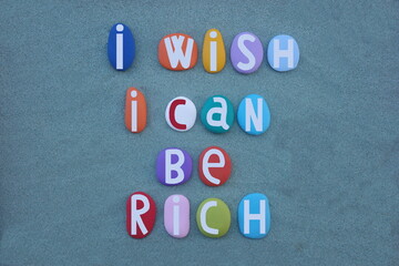 I wish I can be rich, creative text composed with hand painted multi colored stone letters over...