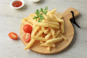 French Fries Served on Wooden Board Coating with Spice and Salt.