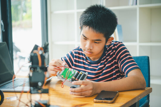 Asian boy learning and studying the work of technology robots.homeschool and science for tech project. playing childhood kids hobby leisure lifestyle people toys robotics technology.