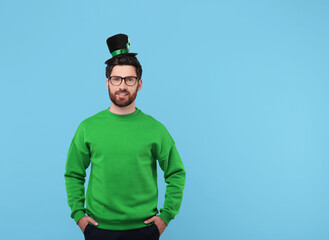 St. Patrick's day party. Man in leprechaun hat on light blue background. Space for text