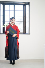 卒業証書を持つ袴を着た女性