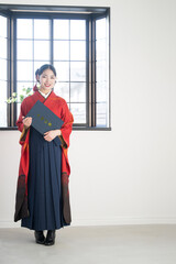 卒業証書を持つ袴を着た女性