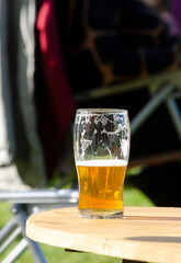 glass of blonde beer on outdoor table