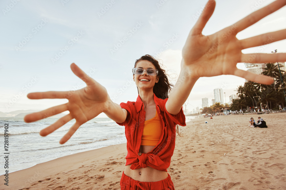 Wall mural colourful sunset: smiling woman with trendy sunglasses and open mouth expressing joy and freedom at 