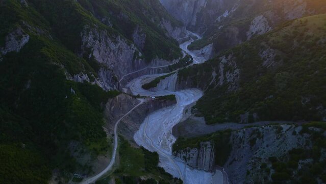 Drone shot flying over the Girdimanchay river near Lahic, Azerbaijan at sunset while panning up.