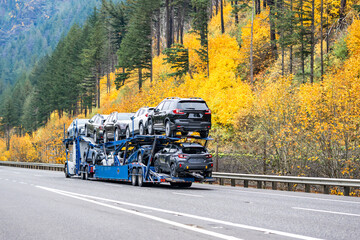 Professional industrial car hauler big rig semi truck transporting car on two level modular semi...