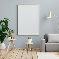 Poster mockup with vertical frames on empty dark blue wall in living room interior with gray velvet sofa