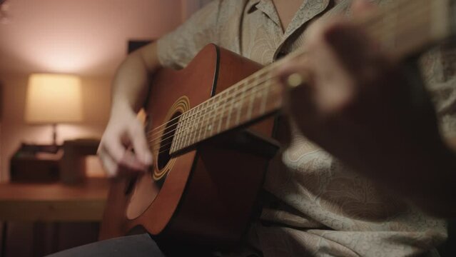 Young musician strumming an acoustic guitar