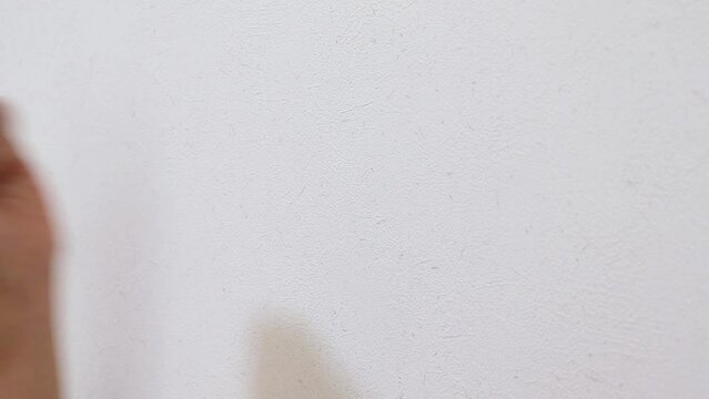 左の拳で壁を何度も叩く