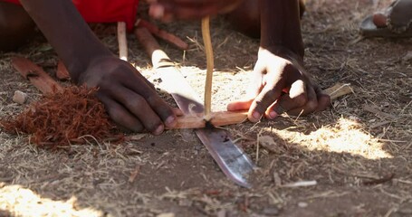 Maasai Man Making Fire By Rubbing Two Sticks Together To Create Friction. - close up shot