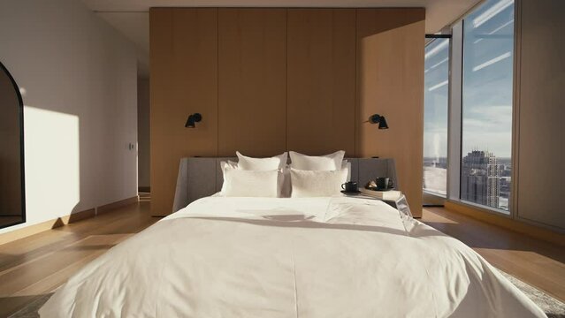 a large white bed inside of a luxury bedroom with large windows letting in natural sunlight
