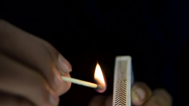 Burning matchstick on black background