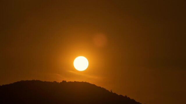 Timelapse of dramatic sunrise with orange sky in a sunny day.