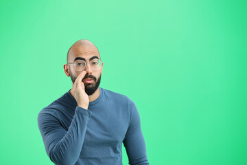 A man, on a green background, in close-up, tells a secret