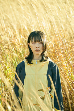 ススキ畑に立つ20代の日本人女性
