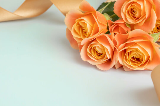 オレンジのバラとゴールドのリボンの愛情のイメージ
