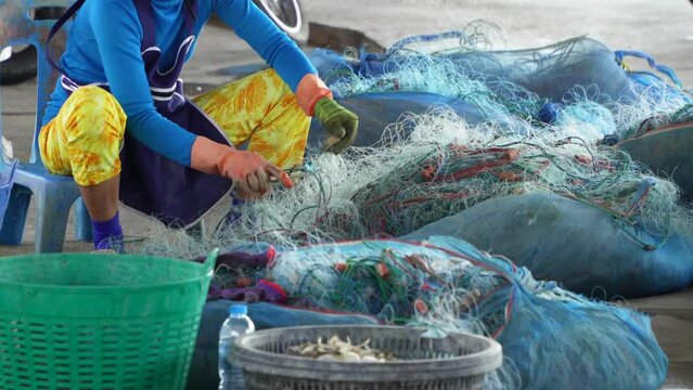 Fisherman cleaning a fishing net