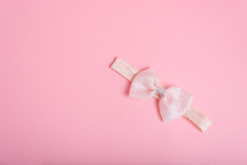 Pink ribbon on pink paper background.