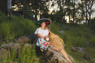 Woman with Mexican hat in rural scenery. Cinco de Mayo celebration in Mexico.