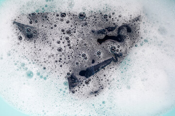 Men's underwear soaked in water dissolved detergent with white foam bubble. Laundry concept