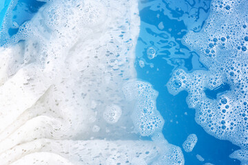 Woman's lace dress soaked in water dissolved detergent with white foam bubble. Laundry concept