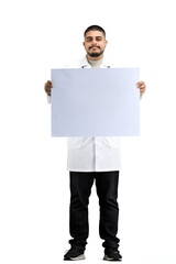 The doctor, in full height, on a white background, shows a white sheet