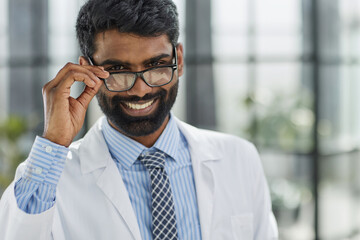 Portrait of a smiling male doctor standing in a hospital corridor