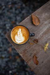 A hot coffee mug is placed on a wooden table. with warm tones in the morning