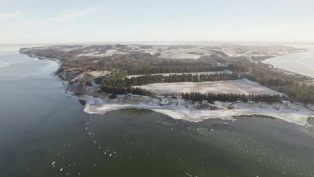 Fur Island in Denmark Under The Snow and Frozen Limfjord Laguna - Aerial Drone Shot