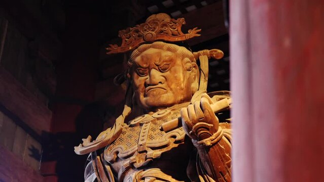 Close-up of an imposing wooden guardian statue at Tōdai-ji Temple, Nara, showcasing intricate carvings