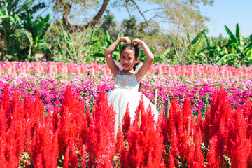 Cute little girl at flower field looking at camera.