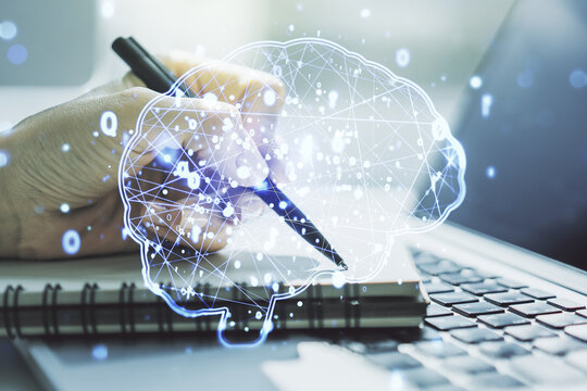 Creative artificial Intelligence concept with human brain sketch and hand writing in diary on background with laptop. Double exposure