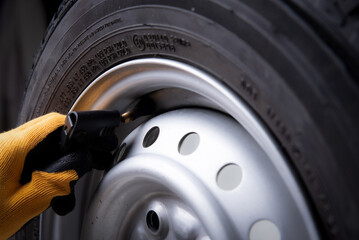 driver checking air pressure and filling air in the tires close up