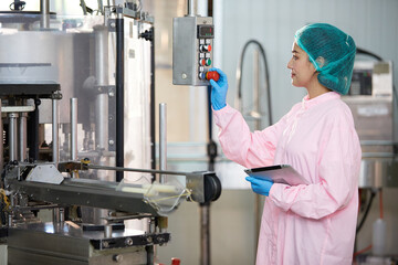 female worker working on machine in the beverage factory