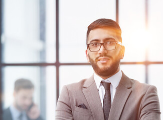 portrait of confident businessman with arms crossed in office