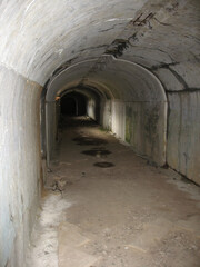 Fototapeta na wymiar Dark narrow concrete underpass, underground Stone tunnel Inside the Vladivostok fortress, Russia