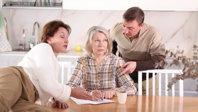 Old woman deciding and signing inheritance papers in family circle. Old woman signing papers. High quality 4k footage