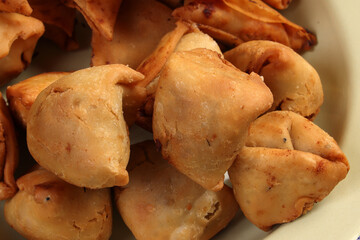 Deep fried samosa singara stuffed with potato minced meat vegetable benglai snacks on enamel tin metal plate