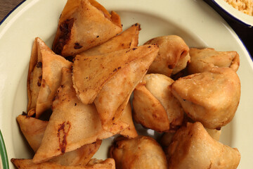 Deep fried samosa singara stuffed with potato minced meat vegetable benglai snacks on enamel tin metal plate