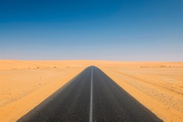 Empty desert road leading towards horizon under clear blue sky in arid landscape