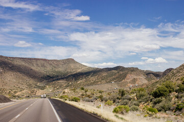 Beautiful blue sky with fluffy clouds over the highway. Scenic road in Arizona, USA on a sunny summer day. 40 hwy, 10 hwy in Arizona, USA - 17 April 2020