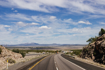 Fototapeta na wymiar Beautiful blue sky with fluffy clouds over the highway. Scenic road in Arizona, USA on a sunny summer day. 40 hwy, 10 hwy in Arizona, USA - 17 April 2020