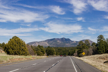 Beautiful blue sky with fluffy clouds over the highway. Scenic road in Arizona, USA on a sunny summer day. 40 hwy, 10 hwy in Arizona, USA - 17 April 2020