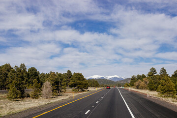 Fototapeta premium Beautiful blue sky with fluffy clouds over the highway. Scenic road in Arizona, USA on a sunny summer day. 40 hwy, 10 hwy in Arizona, USA - 17 April 2020